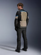 Chaqueta Alpinestars Andes Air Drystar®, negro, gris laurel y azul brillante, vista trasera que muestra un amplio panel de ventilación de malla en la espalda, logotipo en el dobladillo inferior, combinada con pantalones y botas de moto negros.