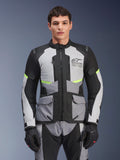 Piloto con chaqueta Alpinestars Andes Air Drystar® en gris hielo, gris oscuro y negro, con detalles en amarillo neón y paneles de ventilación de malla, combinada con pantalones y guantes de moto a juego, equipamiento de adventure touring