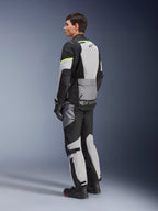 Chaqueta Alpinestars Andes Air Drystar®, chaqueta de moto de touring, color Gris Hielo y Gris Oscuro con paneles negros y detalles en amarillo neón, usada con pantalones y guantes a juego, vista trasera en tres cuartos que muestra la ventilación de malla y la marca Alpinestars