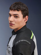 Primer plano de un modelo con la chaqueta Alpinestars Andes Air Drystar® en gris hielo, gris oscuro y negro, con detalles en amarillo neón y paneles de malla, y el logotipo de Alpinestars visible en el hombro.