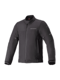 Alpinestars Husker Waterproof Jacket, chaqueta de moto urbana negra, tejido softshell de alta densidad, cuello alto con botón a presión, cremallera frontal completa, correas ajustables en cintura y puños, marca sutil en el pecho y detalles reflectantes en las mangas.