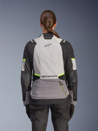 Alpinestars Stella Andes V4 Drystar® Jacket, Woman's Adventure Motorcycle Jacket, back view, Ice Gray, Dark Gray, and Black with Yellow Fluo accents, featuring Alpinestars branding on upper and lower back, durable textile construction for all-weather touring