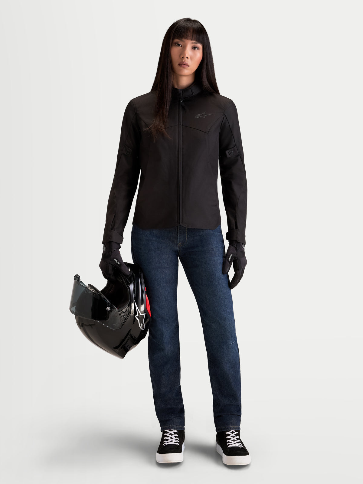 Alpinestars Stella C-1 Waterproof, chaqueta de moto urbana para mujer, negra, vista frontal en modelo sosteniendo un casco