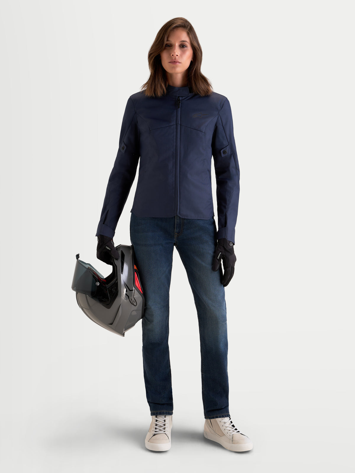Alpinestars Stella C-1 Waterproof Chaqueta, chaqueta de moto urbana contemporánea para mujer en azul, vestida por una modelo sosteniendo un casco, con construcción de tejido textil duradero