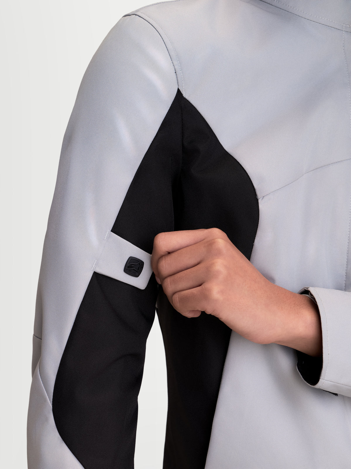 Alpinestars Stella C-1 Waterproof, chaqueta de moto urbana para mujer, gris hielo y negro, vista de cerca de la correa de ajuste en el brazo y la manga ergonómica