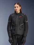 Chaqueta Alpinestars Stella Andes Air Drystar, chaqueta de moto de touring para mujer, negra con detalles grises y un pequeño logotipo rojo, con paneles de ventilación de malla, cuello alto y múltiples bolsillos prácticos, combinada con guantes y pantalones de moto a juego