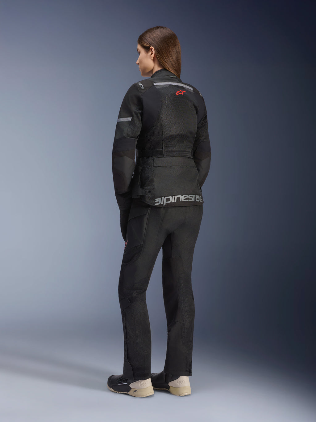Chaqueta Alpinestars Stella Andes Air Drystar®, chaqueta de touring para moto de mujer, negra, vista trasera con pantalones de moto y botas a juego, con amplios paneles de ventilación de malla, logotipo de estrella roja y marca Alpinestars en plateado en la parte inferior de la espalda