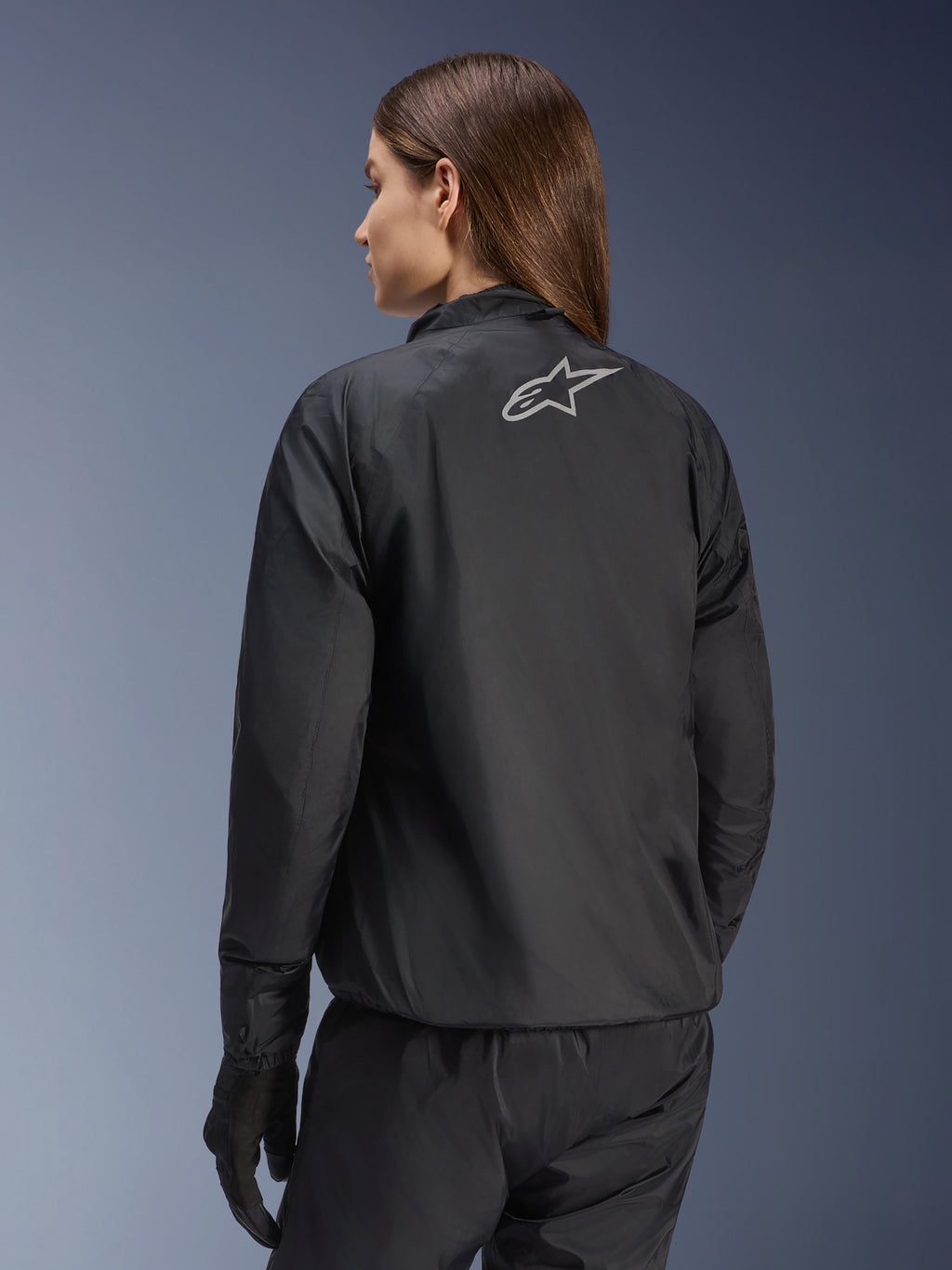 Chaqueta Alpinestars Stella Andes Air Drystar®, chaqueta de moto para mujer, negra, vista trasera que muestra el logotipo de la estrella plateada, combinada con pantalones y guantes negros, equipamiento de touring ligero e impermeable