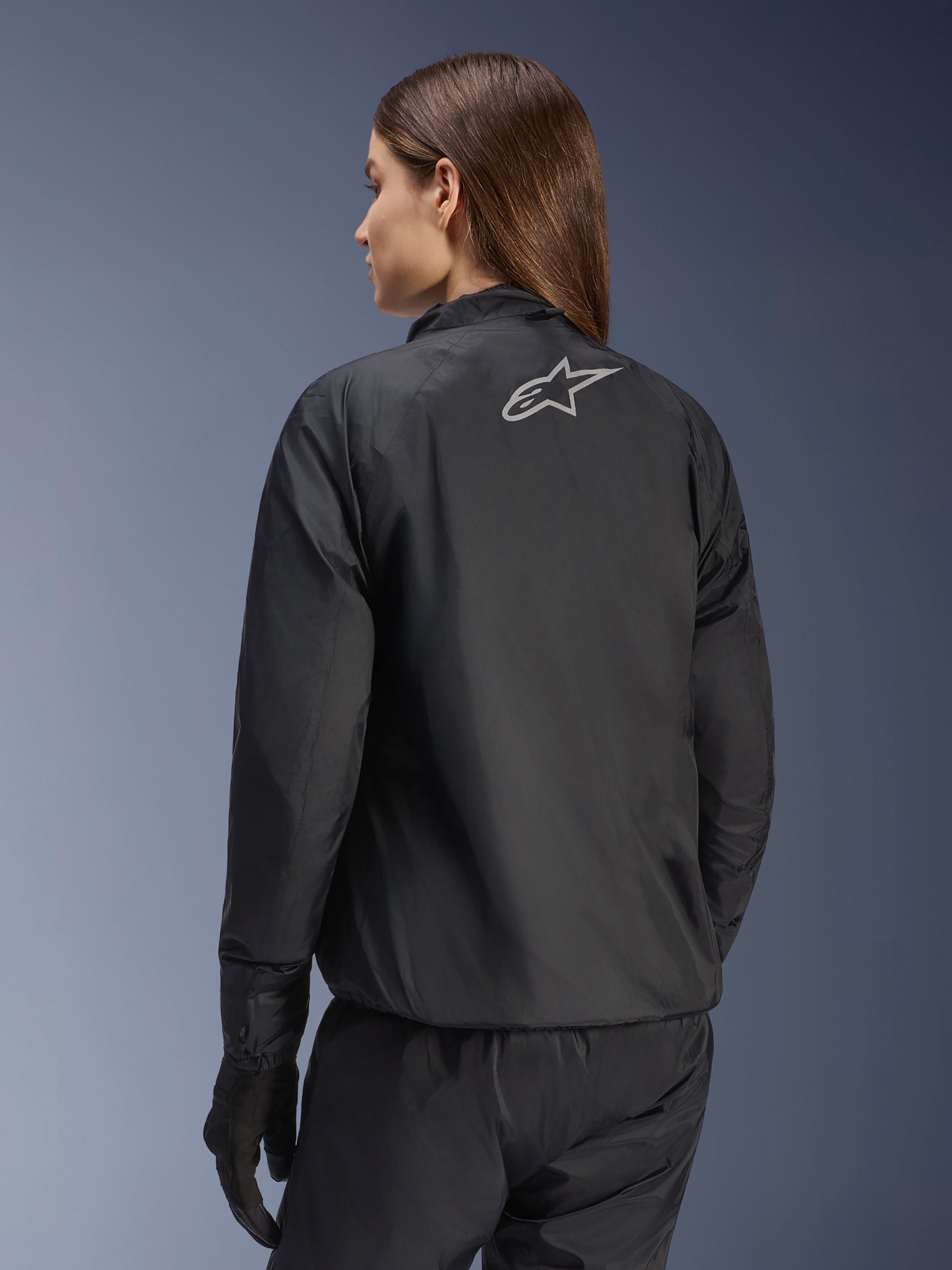 Chaqueta Alpinestars Stella Andes Air Drystar®, chaqueta de moto para mujer, negra, vista trasera que muestra el logotipo de la estrella plateada, combinada con pantalones y guantes negros, equipamiento de touring ligero e impermeable