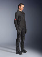 Modelo femenina con la chaqueta Alpinestars Stella ST-2 Air en color negro, combinada con pantalones de moto, guantes y botas negros a juego, con paneles de ventilación de malla y sutiles detalles en rojo, conjunto de touring moderno y elegante