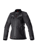Alpinestars Stella Bogota Pro Drystar para mujer, chaqueta de moto adventure touring negra, construcción textil impermeable con múltiples cremalleras frontales y paneles de ventilación, correas ajustables en mangas y cintura, sutiles acentos rojos y logotipo de Alpinestars.