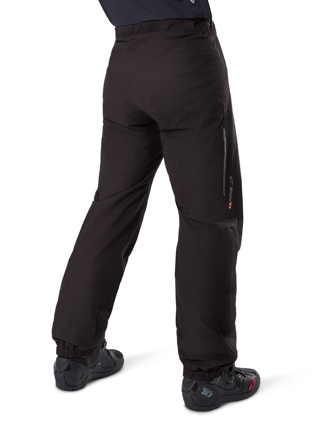 Alpinestars Amt-8 Stretch Drystar® XF Pant Liner, Black, rear view showing the waterproof liner worn over black motorcycle boots, featuring Drystar XF branding on the lower leg, elasticated ankle cuffs, and lightweight stretch material for adventure touring.