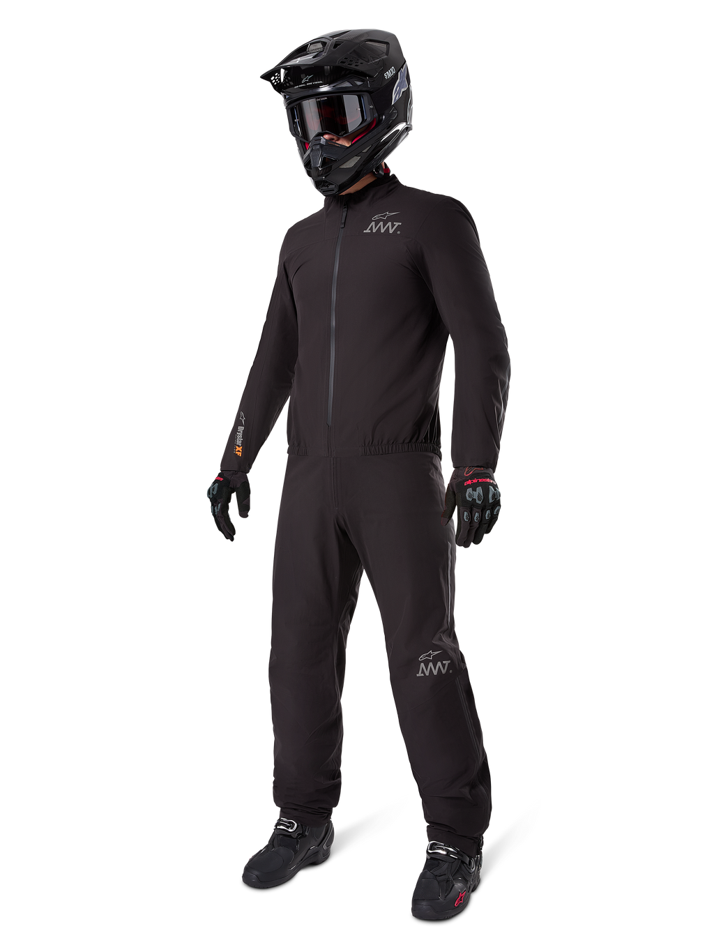 Alpinestars AMT-8 Stretch Drystar XF Liner, full black adventure touring suit, waterproof and windproof jacket and pants, paired with a black adventure helmet, goggles, gloves, and riding boots, featuring AMT logos and Drystar XF branding on sleeves and legs.