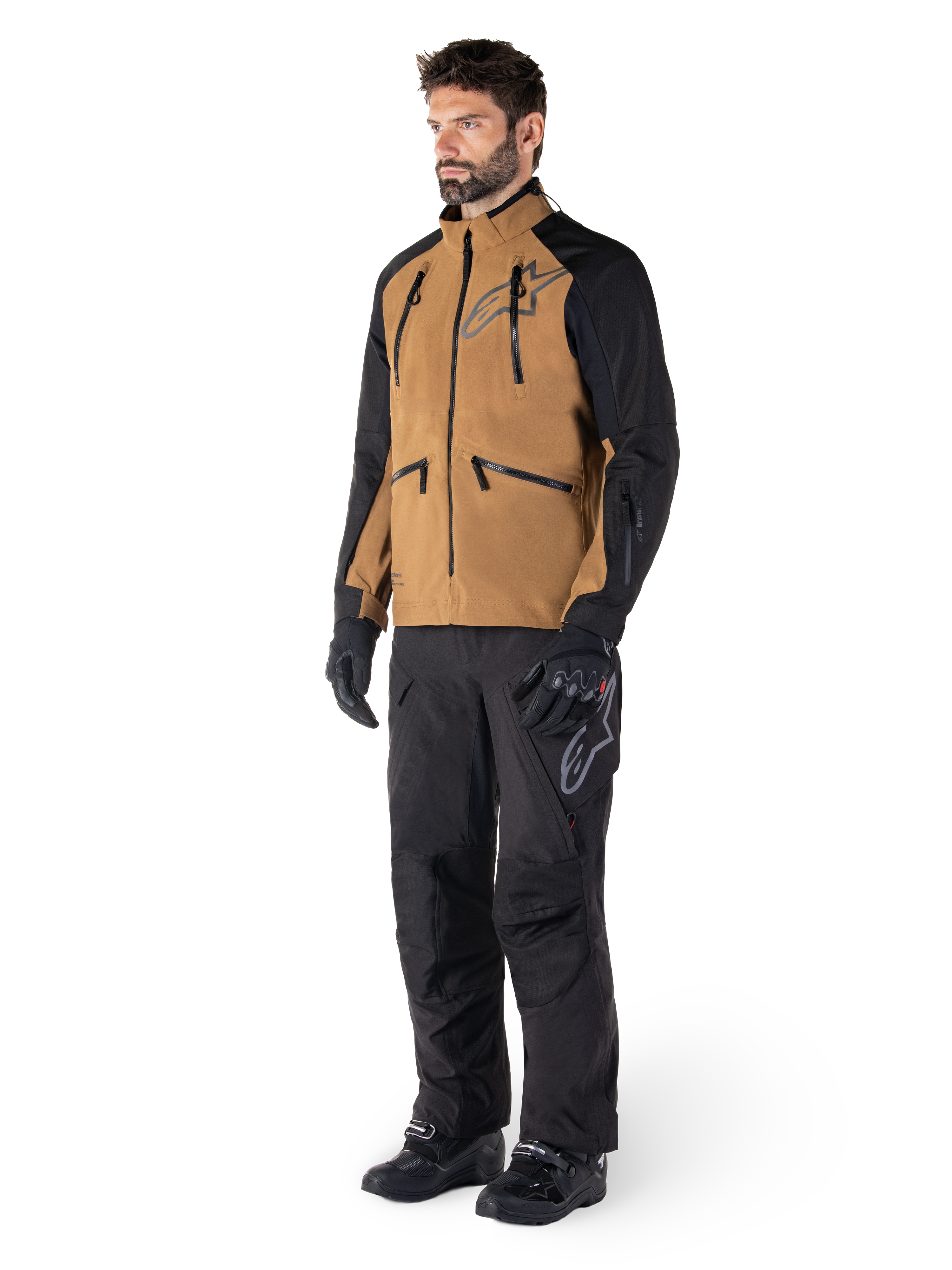 Alpinestars Hyde XT Drystar® Pants, Adventure Motorcycle Pants, Black, worn with a brown and black technical jacket, black gloves and boots, featuring an over-the-boot design for off-road and dual-sport riding