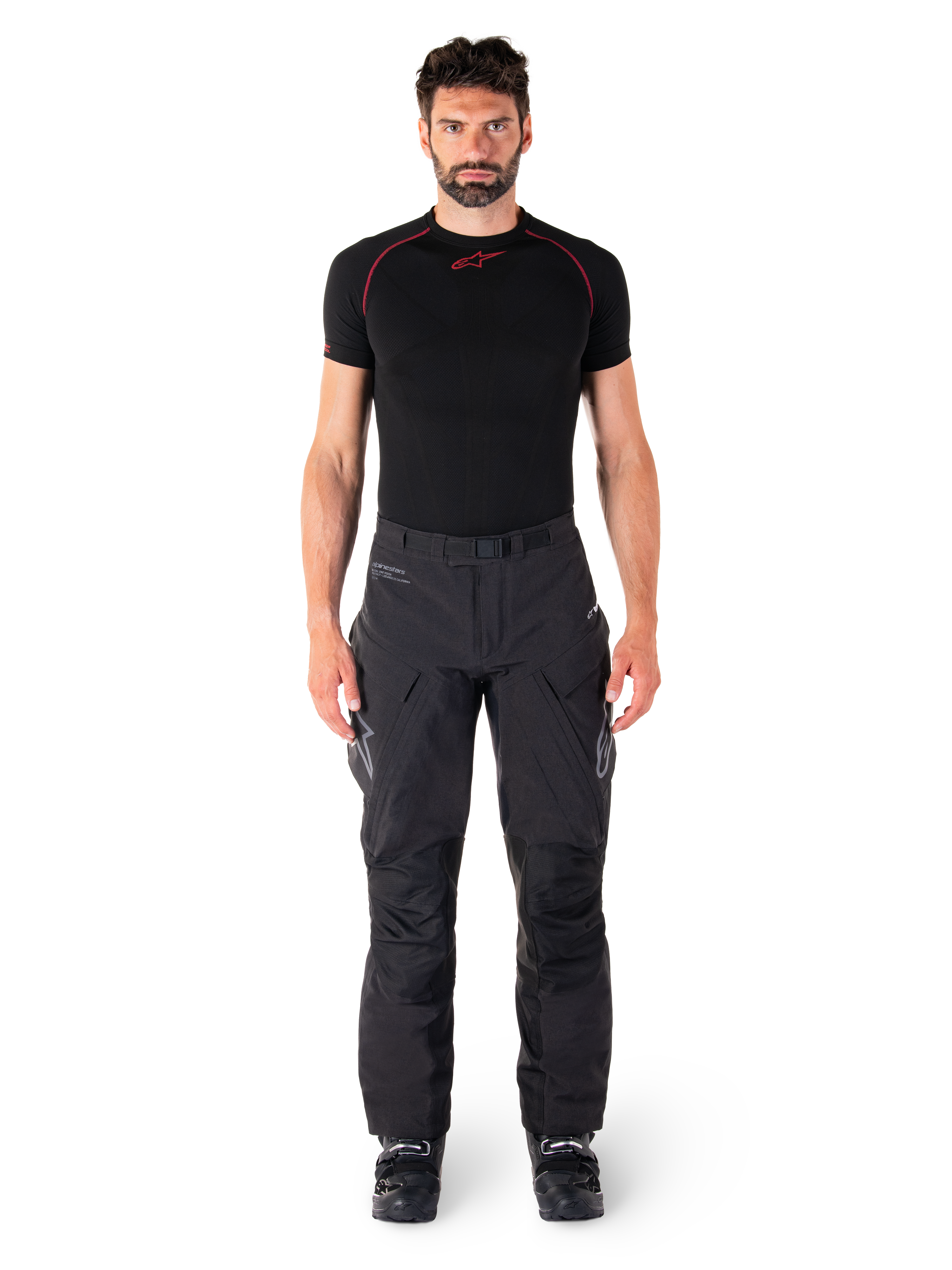 Alpinestars Hyde XT Drystar® Pants, Adventure Touring Motorcycle Pants, Black, worn by a model with a black short-sleeve base layer and black boots, featuring technical stretch material, reinforced knee panels, and ergonomic cargo pockets.