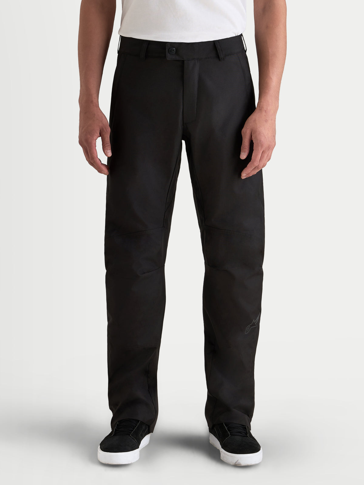 Alpinestars C-1 Waterproof Pantalones, pantalones de moto urbanos contemporáneos para hombre, de color negro, vista frontal en un modelo que lleva una camiseta blanca