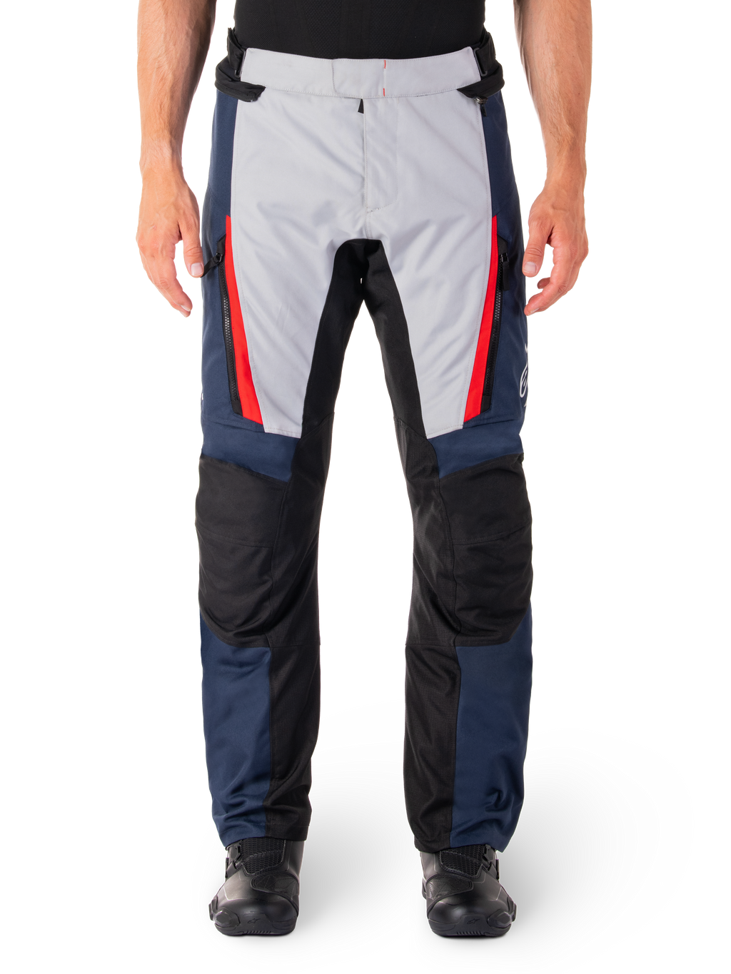 Pantalones Alpinestars ST-1 Waterproof, pantalones de turismo para moto, azul oscuro y gris claro con detalles en rojo brillante, paneles negros reforzados en las rodillas, vista frontal con botas negras, equipamiento de turismo de aventura impermeable