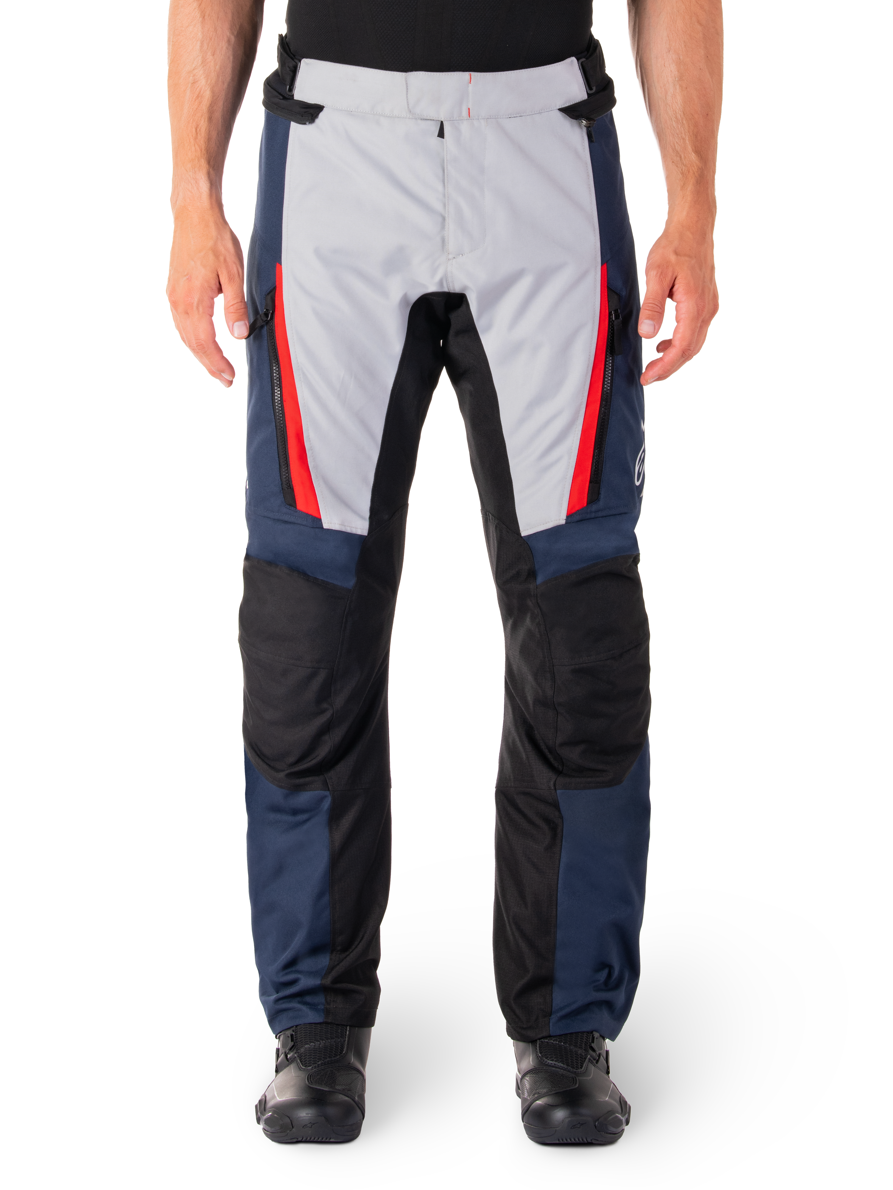 Pantalones Alpinestars ST-1 Waterproof, pantalones de turismo para moto, azul oscuro y gris claro con detalles en rojo brillante, paneles negros reforzados en las rodillas, vista frontal con botas negras, equipamiento de turismo de aventura impermeable