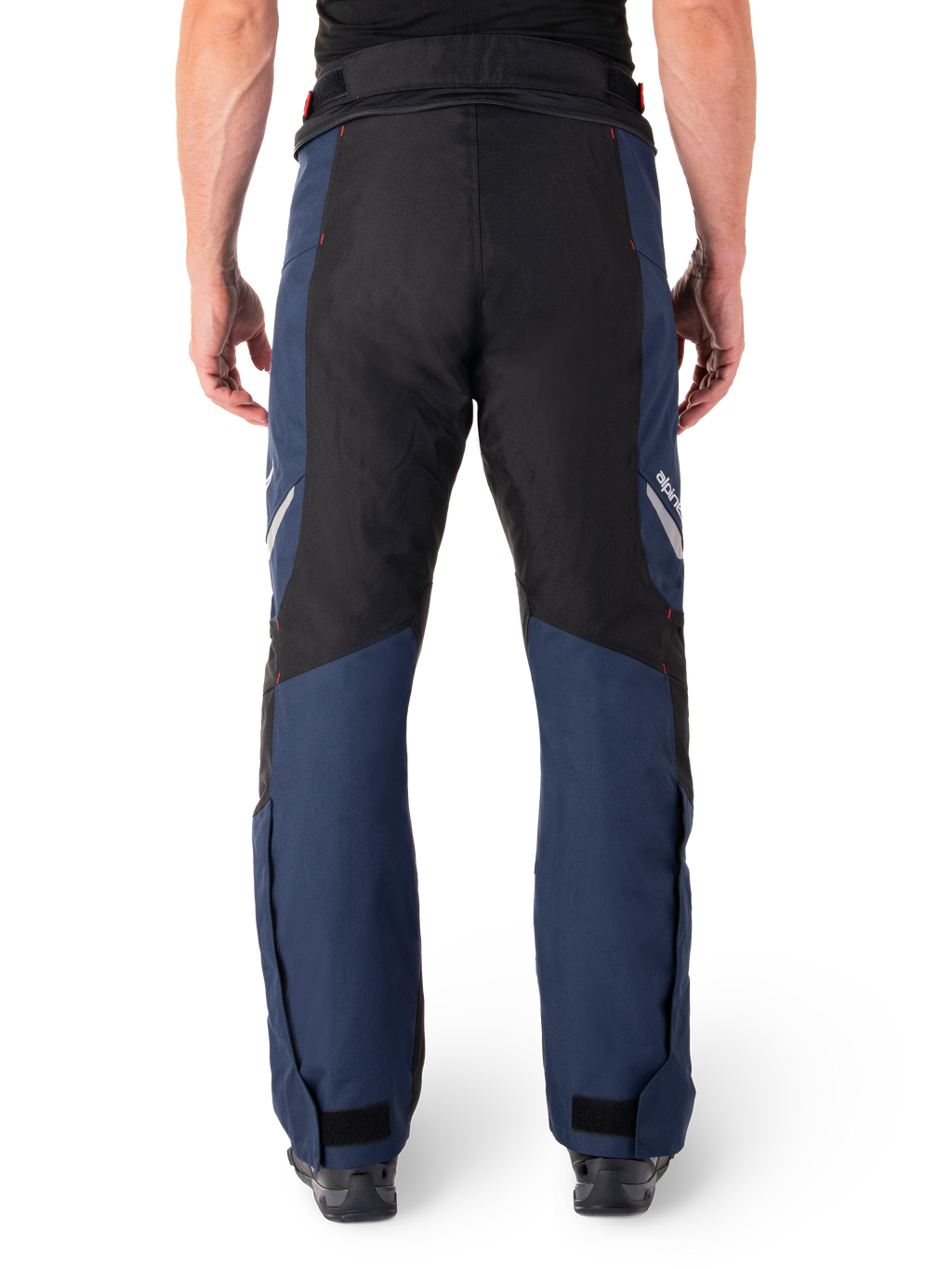 Pantalones Alpinestars St-1 Waterproof, pantalones de moto para turismo, azul oscuro y negro con detalles en rojo brillante, vista trasera, diseño aerodinámico con construcción textil duradera, marca reflectante y cierres ajustables en los tobillos.