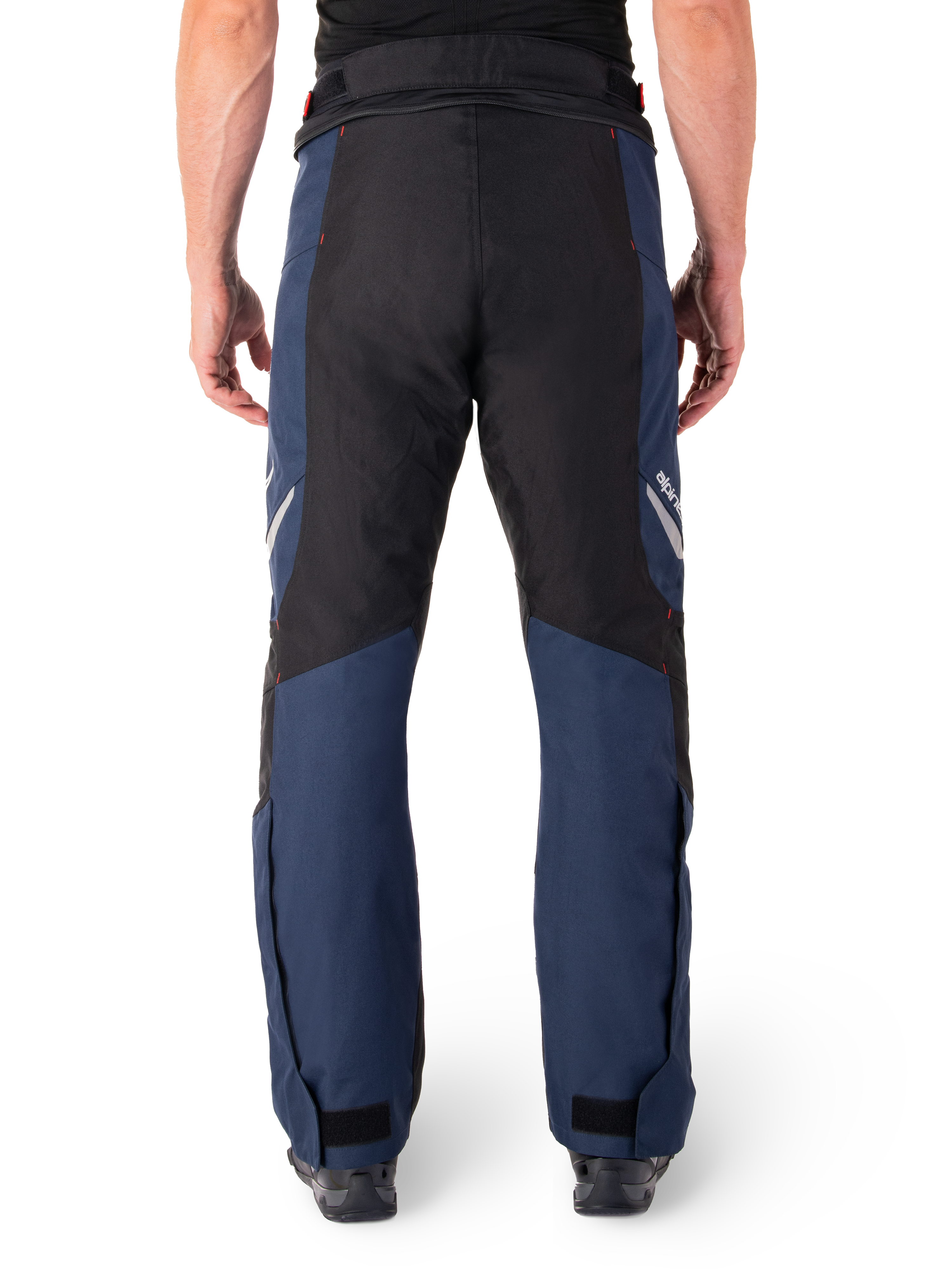 Pantalones Alpinestars St-1 Waterproof, pantalones de moto para turismo, azul oscuro y negro con detalles en rojo brillante, vista trasera, diseño aerodinámico con construcción textil duradera, marca reflectante y cierres ajustables en los tobillos.