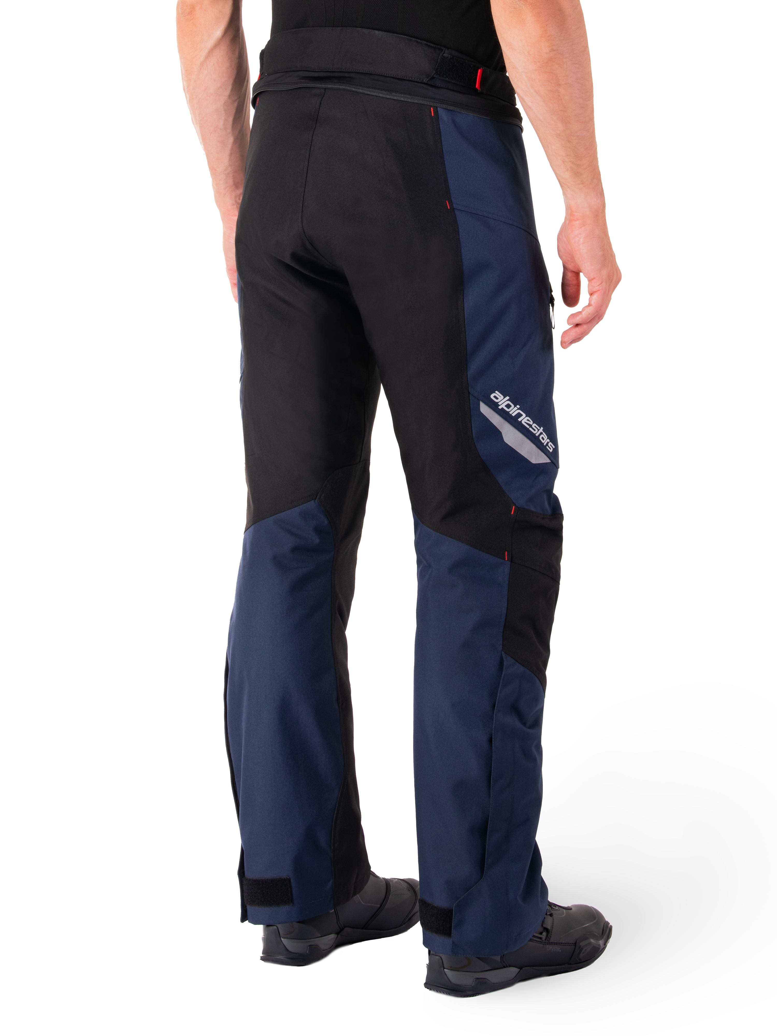 Pantalones impermeables Alpinestars St-1, azul oscuro, negro y rojo brillante, vista trasera con paneles de contraste negros, logotipo reflectante de Alpinestars en el lateral del muslo y ajuste ergonómico para turismo en motocicleta