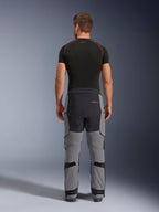 Alpinestars Andes Pro Drystar® XF Pants, pantalones de motociclismo de aventura, gris oscuro y negro, vista posterior que muestra la construcción de paneles en gris y negro, usados con una capa base negra, con asiento reforzado y correas de ajuste en la pantorrilla para touring