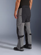 Pantalones Alpinestars Andes Pro Drystar® XF, pantalones de motociclismo de aventura, gris oscuro y negro, vista trasera de tres cuartos, con construcción textil con asiento y paneles internos de la pierna reforzados en negro, cremalleras en la parte inferior de la pierna y correas ajustables.