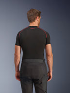 Pantalones Alpinestars Cusco Drystar®, pantalones de moto negros, vista trasera de un piloto con equipamiento adventure touring, camiseta de compresión negra de manga corta con costuras rojas, construcción duradera en tejido ripstop y 600D.