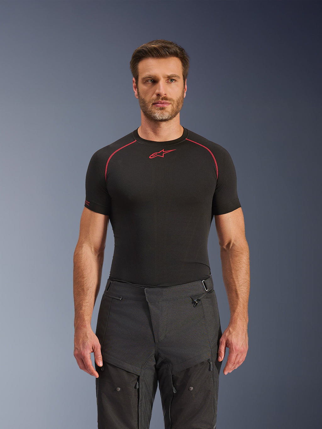 Pantalones Alpinestars Cusco Drystar®, pantalones de moto para aventura, negros, construcción en tejido técnico con ventilación con cremallera y paneles ripstop, usados por un modelo masculino con una camiseta de capa base Alpinestars negra para un look de aventura completo