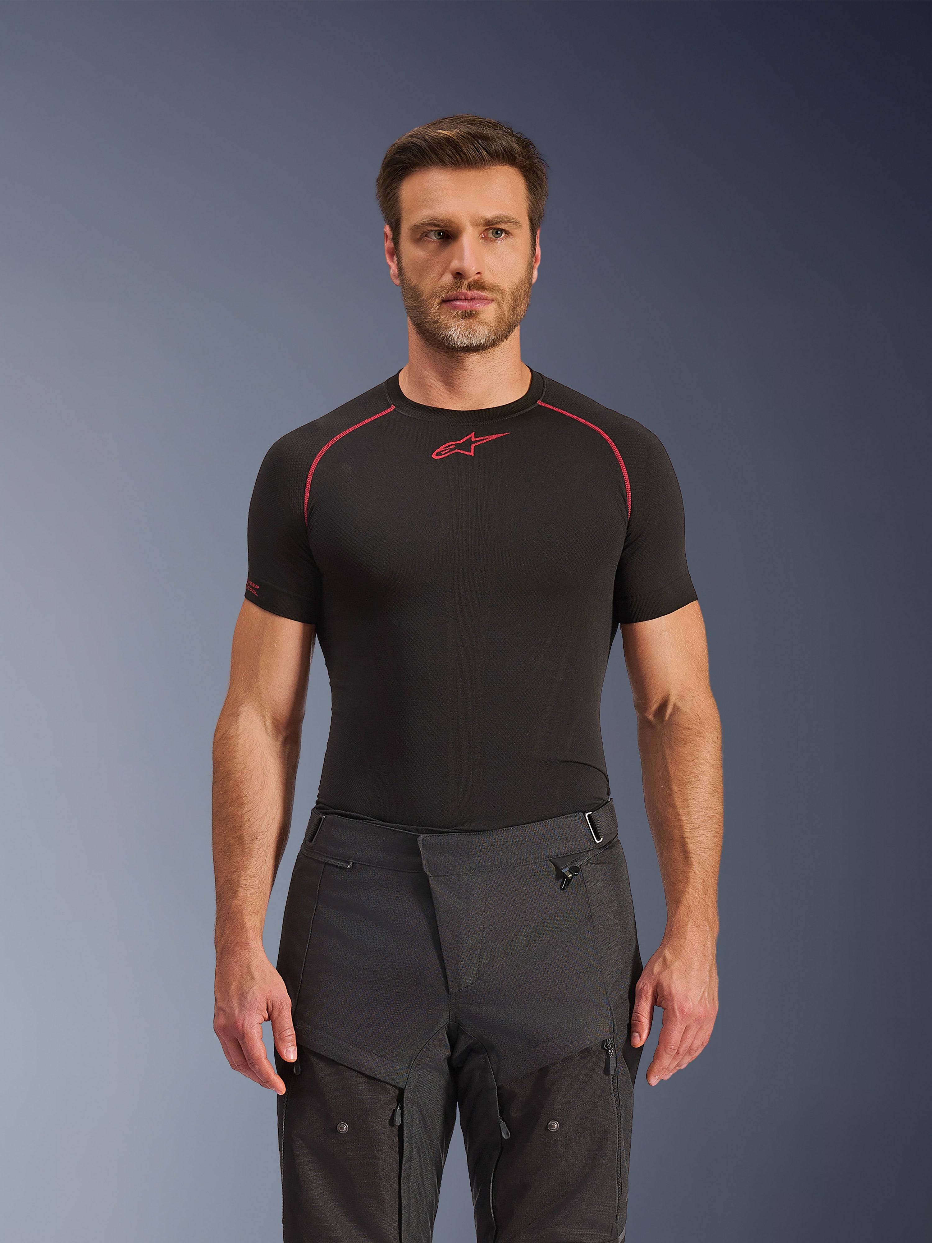 Pantalones Alpinestars Cusco Drystar®, pantalones de moto para aventura, negros, construcción en tejido técnico con ventilación con cremallera y paneles ripstop, usados por un modelo masculino con una camiseta de capa base Alpinestars negra para un look de aventura completo
