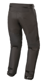Alpinestars Raider V2 Drystar® Pants, pantalones textiles para moto, negros, vista trasera que muestra la cremallera de conexión en la cintura y correas de velcro ajustables en la parte posterior de las piernas y los tobillos.