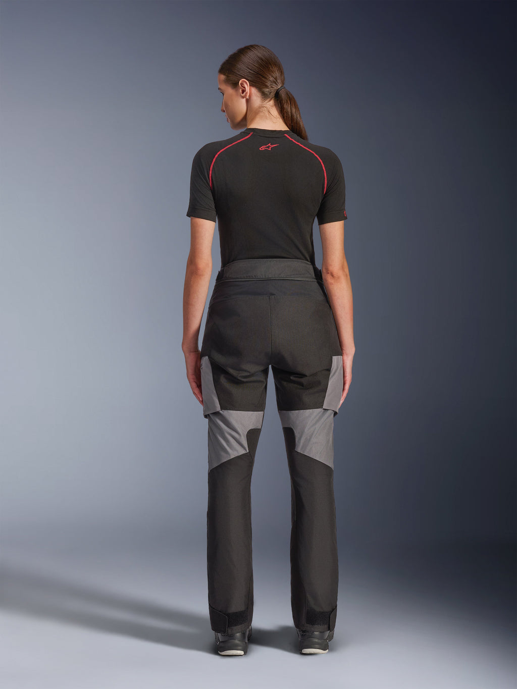 Pantalones Alpinestars Stella Andes V4 Drystar®, pantalones de moto para mujer, negro y gris oscuro, vista trasera que muestra los refuerzos de ripstop grises y el diseño ergonómico, usados con una capa base técnica negra, equipamiento de conducción adventure touring