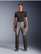 Pantalones Alpinestars Stella Andes V4 Drystar, pantalones de moto adventure touring para mujer, negro y gris oscuro, usados por una modelo con una capa base negra y botas de moto, con paneles textiles reforzados y bolsillos de carga para conducción de aventura
