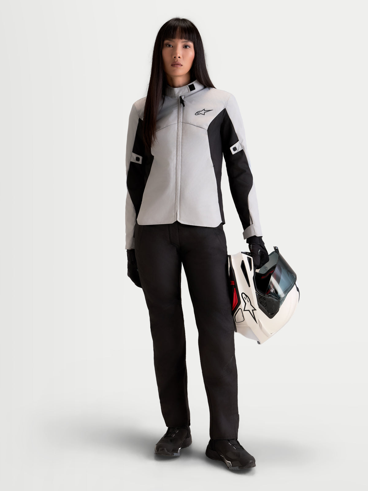 Alpinestars Stella C-1 Waterproof Pantalones, pantalones de moto urbanos para mujer, negros, vista frontal en modelo con chaqueta a juego y casco, equipo de protección impermeable con certificación A
