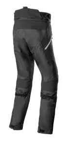 Pantalones Alpinestars Stella Bogotá Pro Drystar 4 Seasons, pantalones de aventura para moto de mujer, negros, vista trasera que muestra la construcción técnica textil, correas ajustables en la pantorrilla y detalles reflectantes laterales.