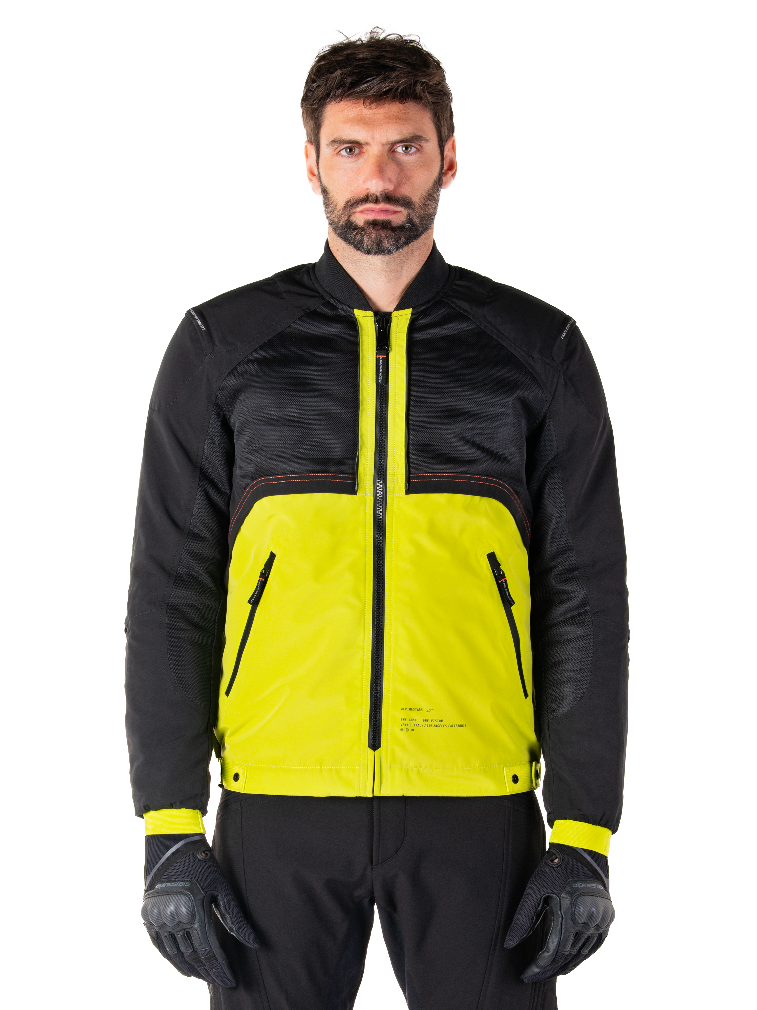 Parka impermeable Mootant, chaqueta modular de moto, Lime Punch y negro, vestida por un modelo masculino con guantes y pantalones negros, con la parte inferior en amarillo vibrante y el torso superior y las mangas en negro, diseño utilitario para conducción en cualquier clima