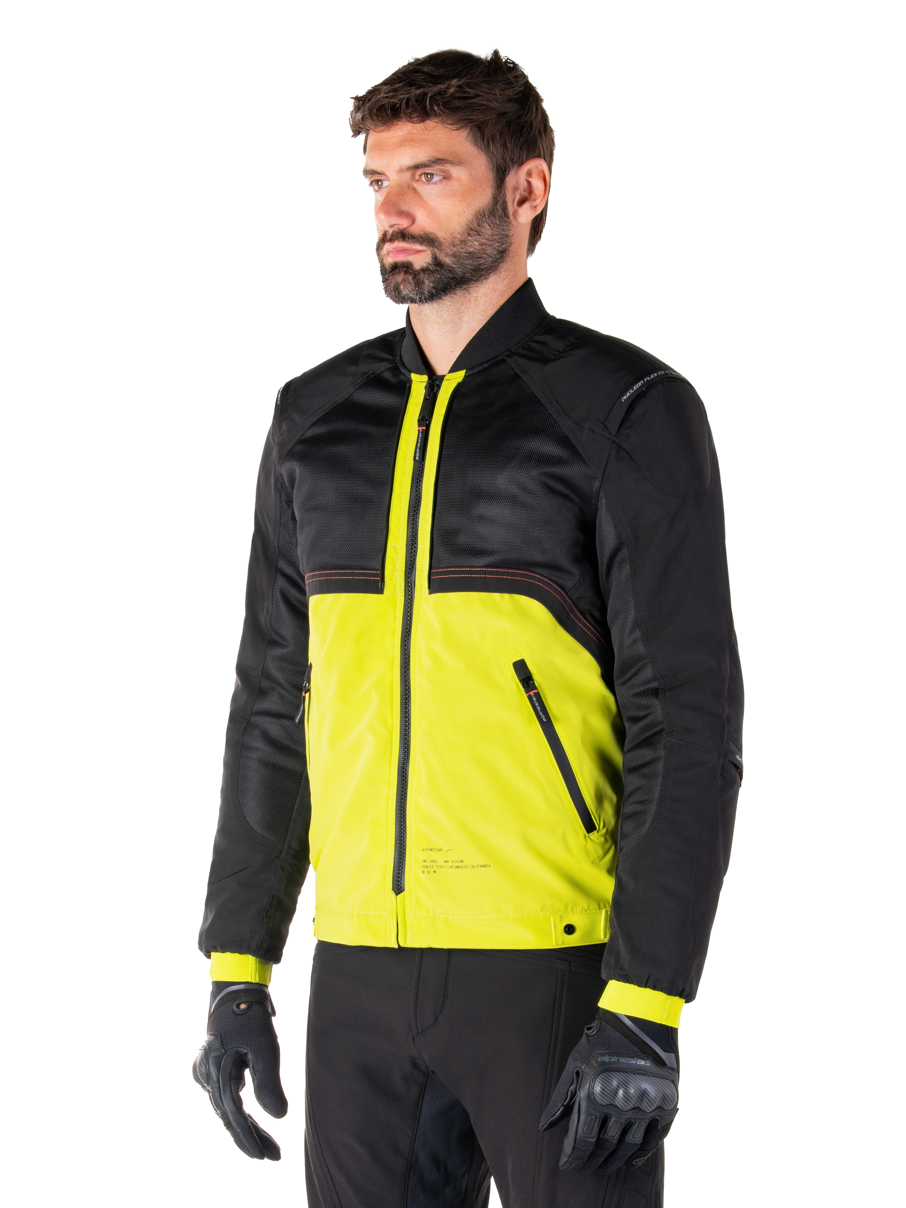 Alpinestars Mootant Waterproof Parka en Lime Punch Black, chaqueta modular de motociclismo con parte superior de malla negra y cuerpo inferior en verde lima vibrante, vestida por un piloto masculino con guantes y pantalones negros, estilo de conducción urbano contemporáneo.