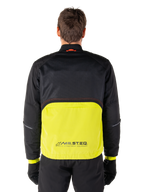 Parka impermeable Alpinestars Mootant, chaqueta de moto, color Lime Punch y negro, vista posterior con parte superior de malla negra para ventilación y sección inferior en color lima con el logo MO.ST.EQ., combinada con pantalones y guantes negros