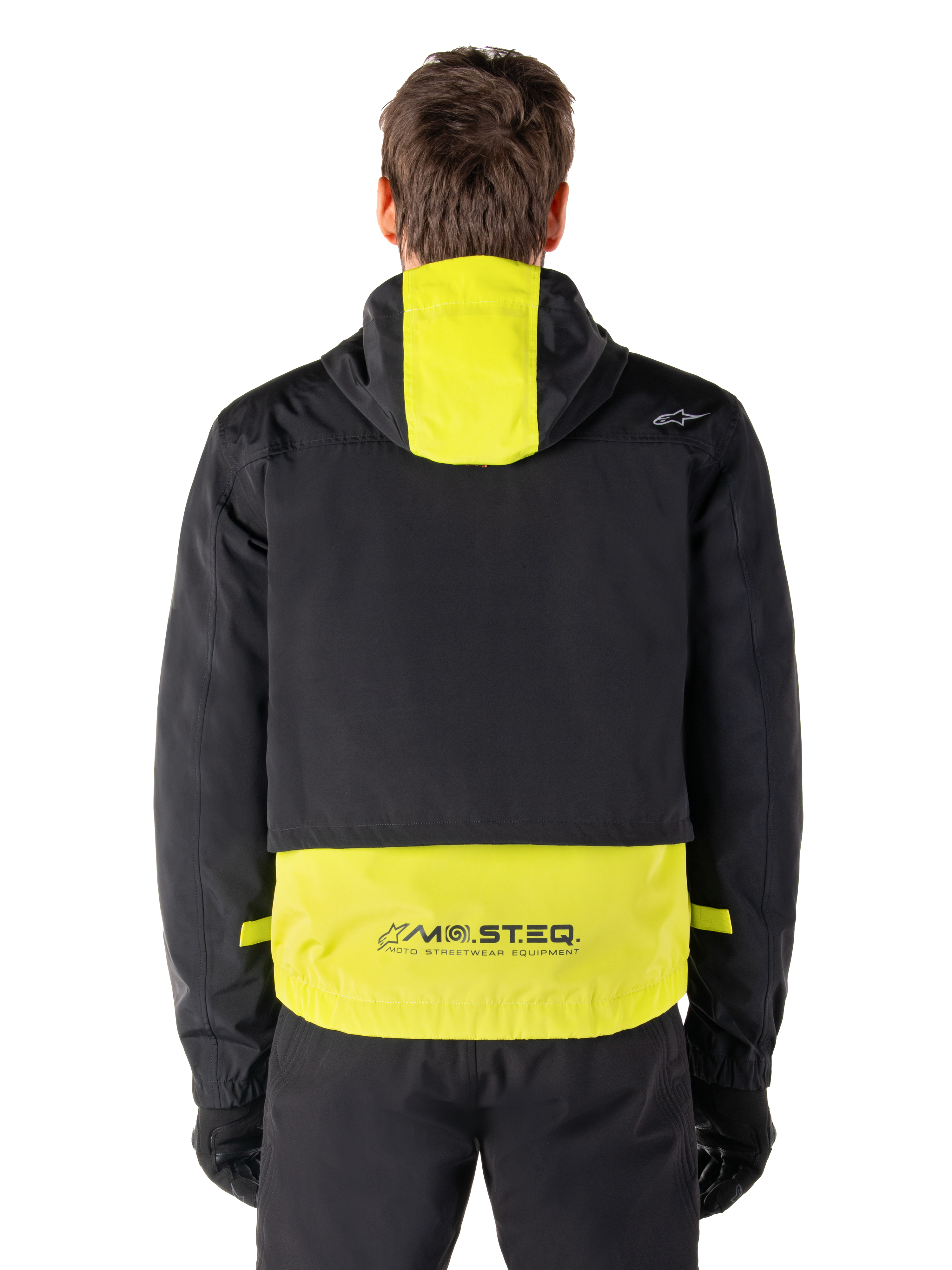 Parka impermeable Alpinestars Mootant, chaqueta de moto, en Lime Punch y negro, vista trasera que muestra el diseño con capucha y la marca reflectante MO.ST.EQ. en la parte inferior de la espalda, combinada con pantalones y guantes de moto negros.