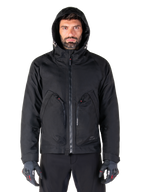 Alpinestars Morush Waterproof Parka, Black, Urban motorcycle jacket with a hood and large front utility pockets, worn by a model with protective riding gloves, minimalist and contemporary streetwear-inspired design.