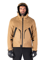 Parka impermeable Alpinestars Morush, chaqueta de moto, marrón utility, diseño con capucha inspirado en el estilo urbano con grandes bolsillos delanteros con detalles en negro, usada con guantes y pantalones de moto negros, equipamiento de moto urbano contemporáneo