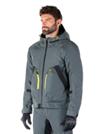 Parka impermeable Alpinestars Morush, chaqueta de moto en Urban Gray, diseño con capucha con detalles de cremalleras en amarillo brillante, detalles de bolsillos en negro, combinada con pantalones de conducción grises a juego y guantes negros, ropa de motociclismo contemporánea de inspiración urbana.