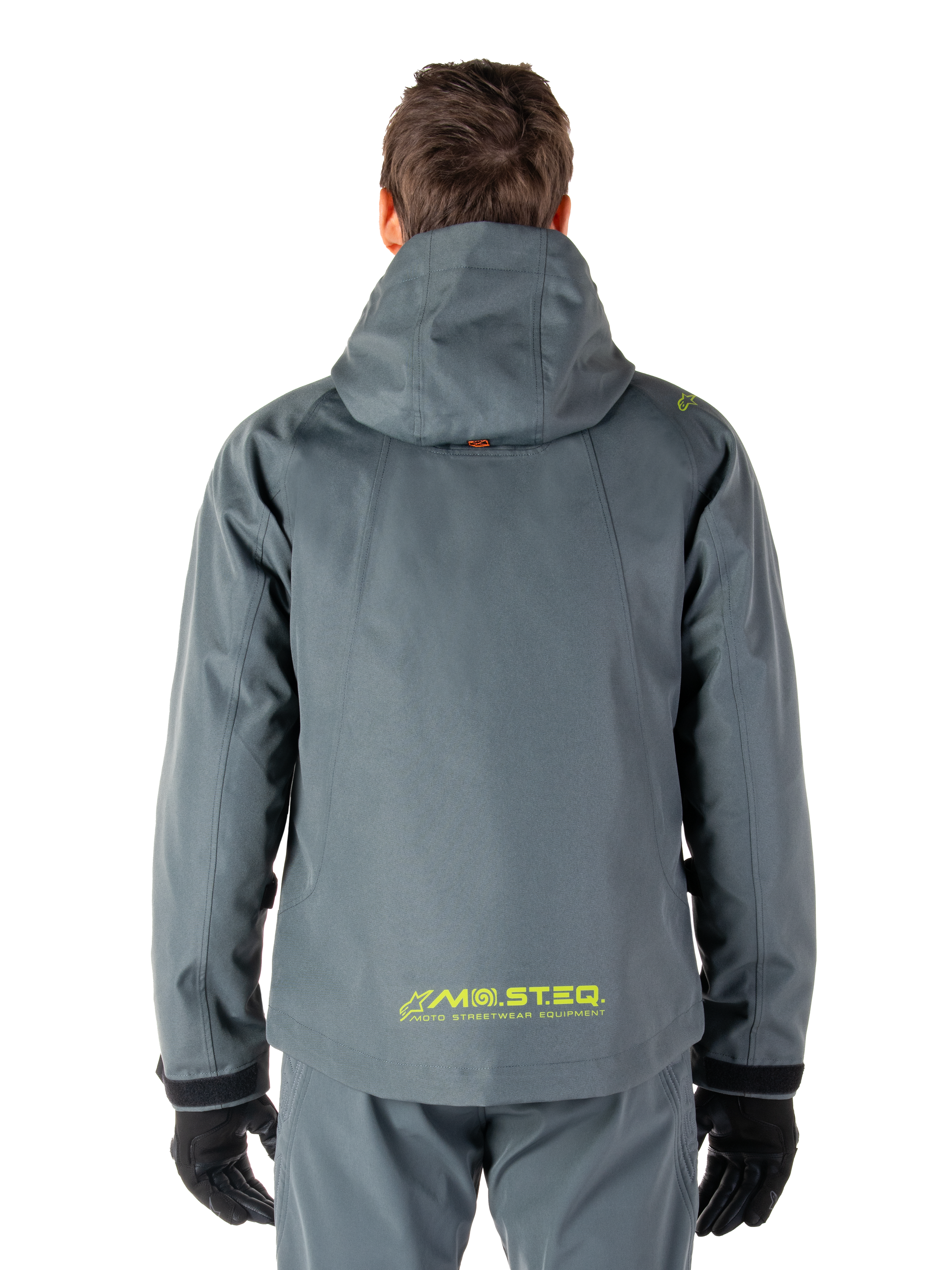 Parka impermeable Alpinestars Morush, chaqueta de moto, Gris Urbano, vista trasera que muestra el diseño con capucha y el logotipo MO.ST.EQ. amarillo en la parte inferior de la espalda, equipamiento de moto moderno inspirado en el estilo urbano
