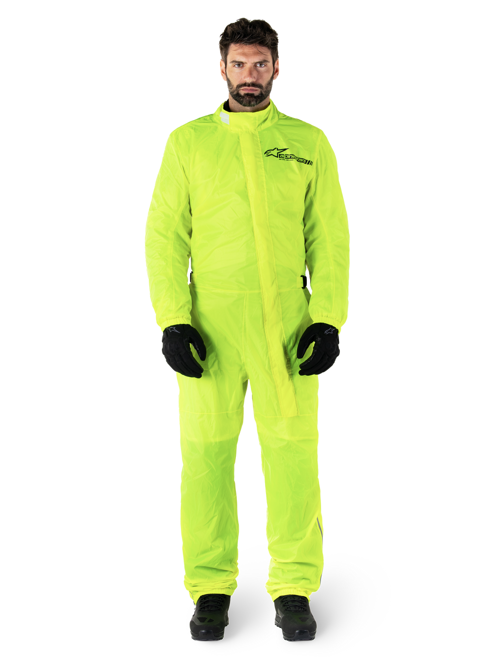 Alpinestars Hurricane Rain V2 Suit, traje impermeable para moto, amarillo flúor, modelo masculino con protección de cuerpo completo, guantes y botas negros, cuello alto con solapa frontal contra tormentas, logotipo reflectante en el pecho, equipo impermeable de alta visibilidad