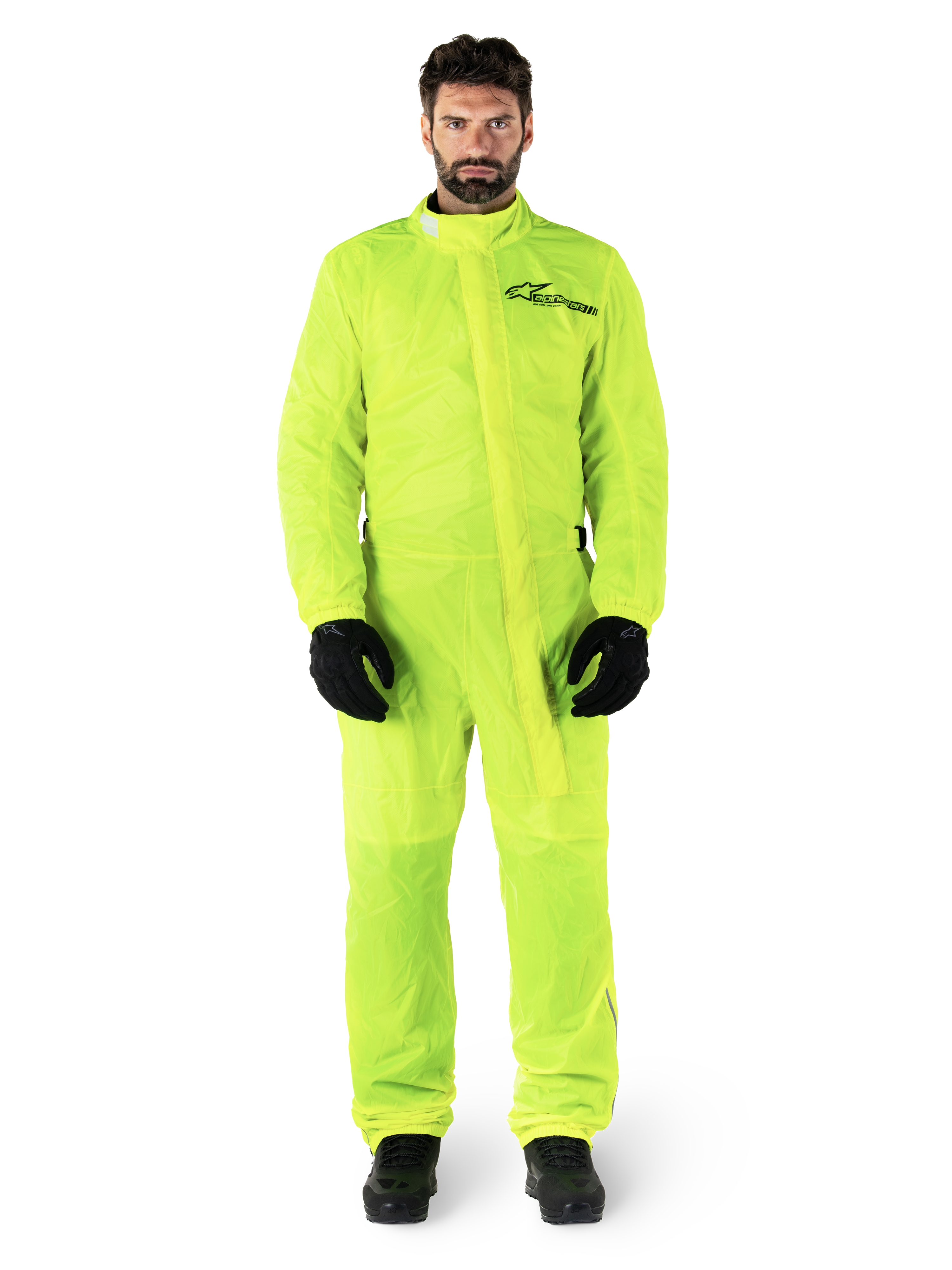 Alpinestars Hurricane Rain V2 Suit, traje impermeable para moto, amarillo flúor, modelo masculino con protección de cuerpo completo, guantes y botas negros, cuello alto con solapa frontal contra tormentas, logotipo reflectante en el pecho, equipo impermeable de alta visibilidad