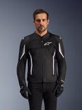 Chaqueta Alpinestars AST V3 Air, chaqueta de moto, negra, gris oscuro y blanca, usada por un hombre con guantes negros a juego, con paneles de malla técnica para el flujo de aire y construcción de ajuste deportivo para la conducción en climas cálidos