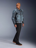 Chaqueta Alpinestars Flight Air, Gris Storm Gray, chaqueta de motociclismo de inspiración bomber urbana, vestida por un modelo masculino con pantalones negros y zapatillas, con paneles de ventilación de malla 3D extendidos y bolsillos externos para protectores, equipamiento de estilo urbano para conducir en climas cálidos