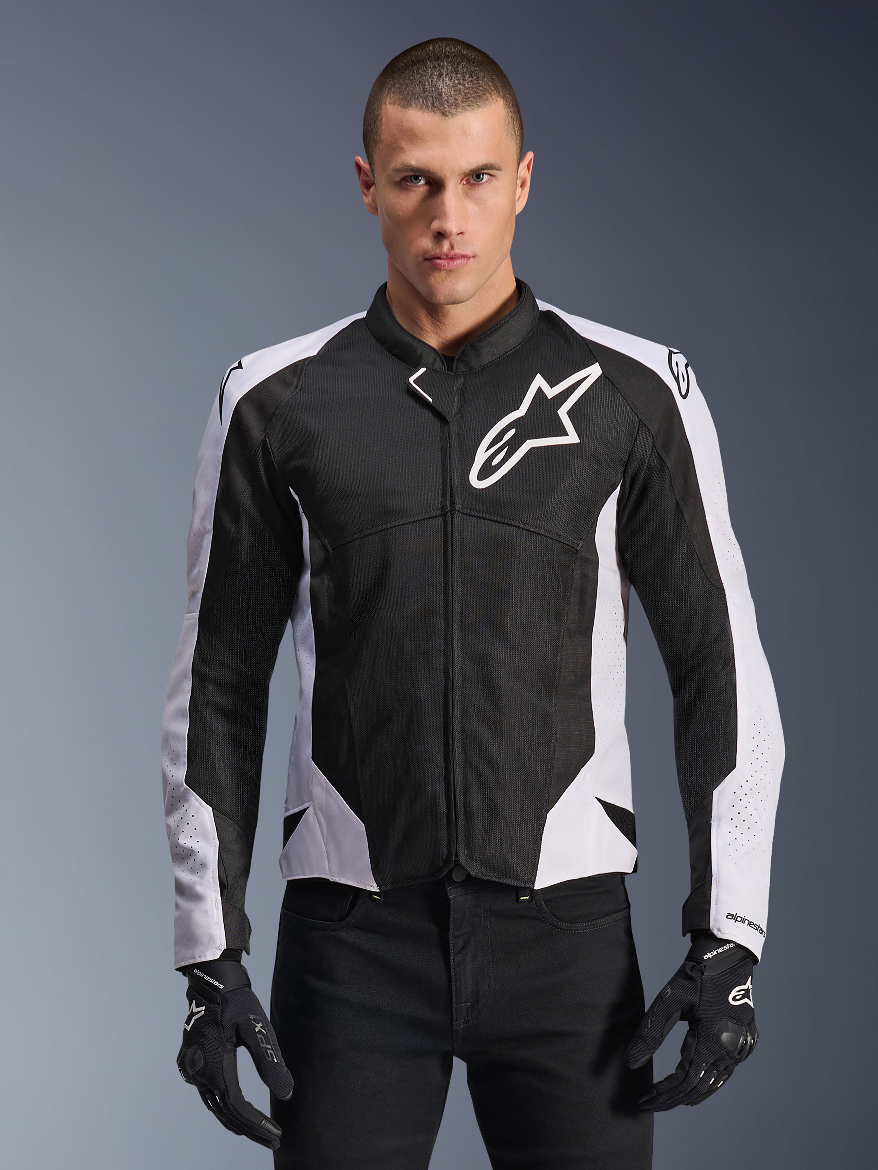 Alpinestars Viper Air V4 Jacket, Motorcycle Racing Jacket, Black and White, worn by rider, tech mesh and textile construction with white shoulder panels, prominent star logo on chest, sport performance design, paired with black riding gloves