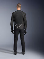 Chaqueta Alpinestars T-Sps Air V2, vista trasera, chaqueta de moto textil en negro y blanco, con un gran panel de malla en la espalda para un flujo de aire máximo y logotipo de Astars en blanco en la parte inferior de la espalda, combinada con pantalones y guantes de conducción negros