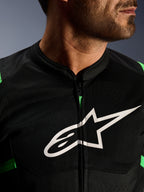 Primer plano de la chaqueta Alpinestars T-SPS Air V2, en color negro y verde flúor, con paneles de malla técnica transpirable, cremallera central y el destacado logotipo blanco de la estrella de Alpinestars en el pecho, equipamiento de motociclismo de alto rendimiento